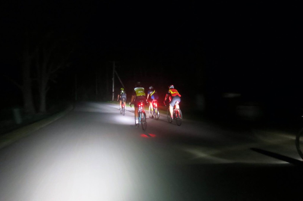 Four riders pedal into the darkness