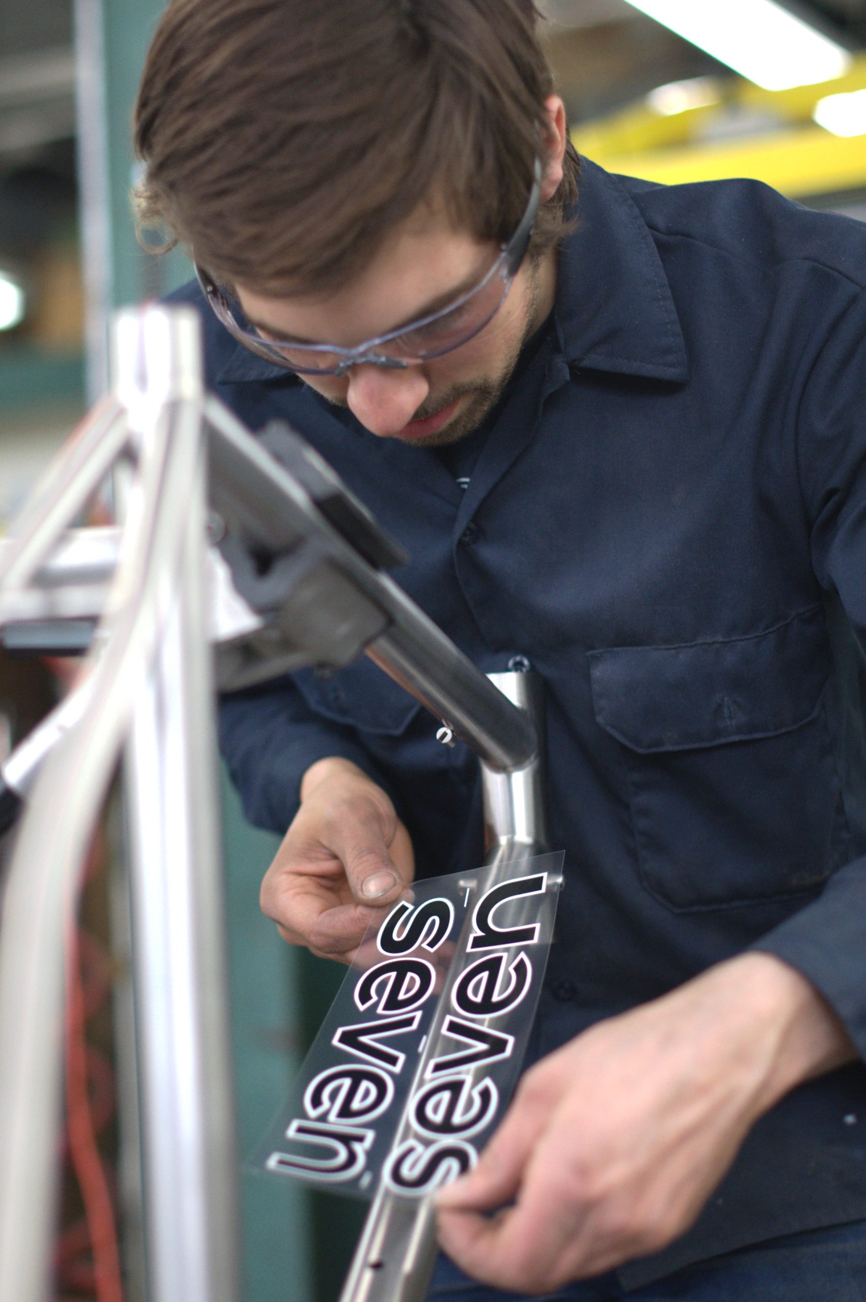 Matt applies a decal to a brushed titanium frame