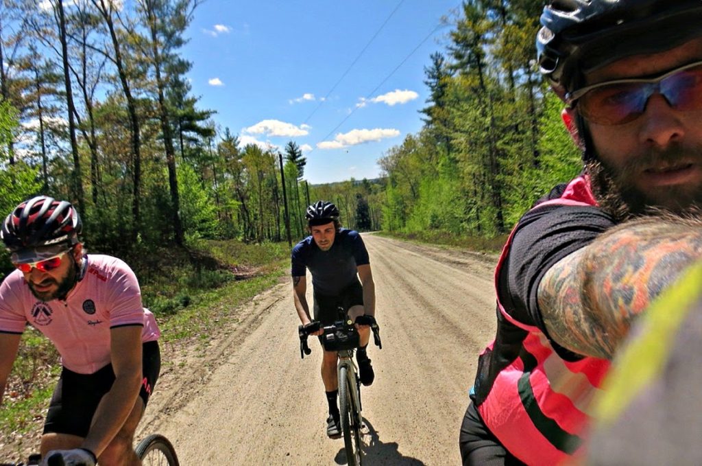 Three riders ascend a smooth dirt road