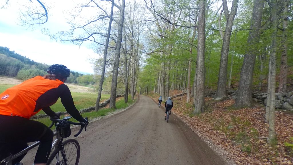 Three riders descend a smooth dirt road