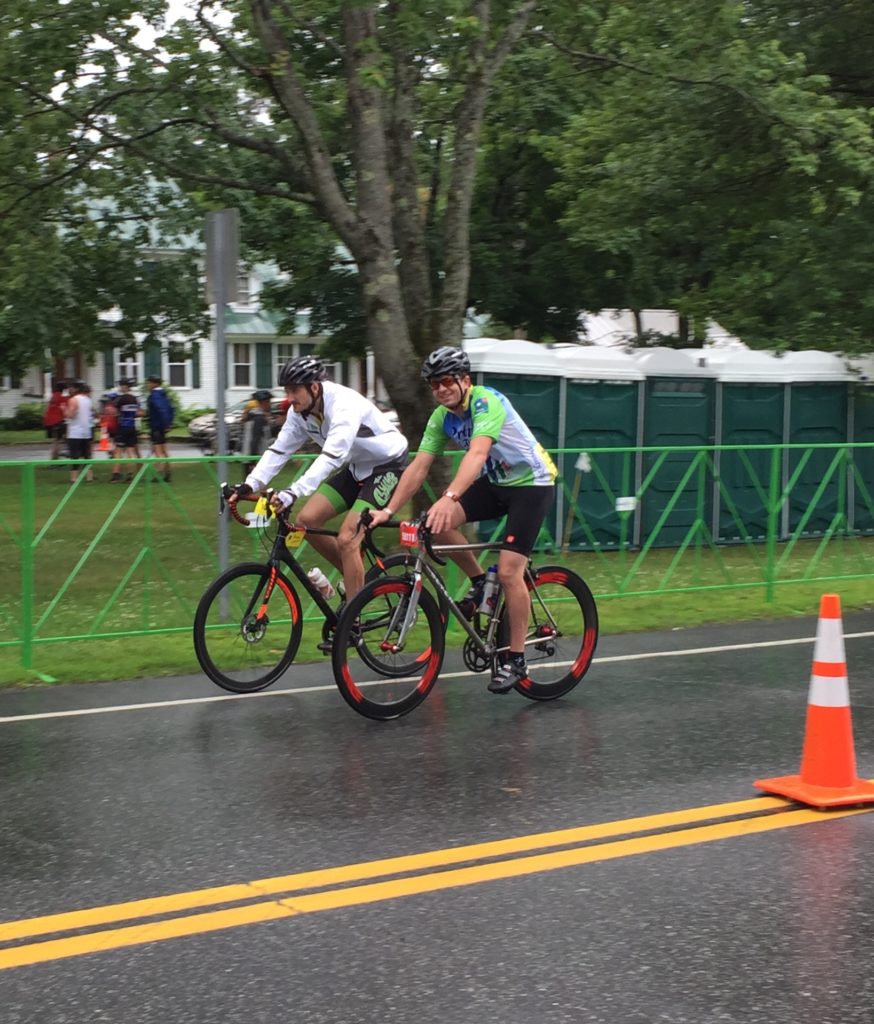 Two road riders in smiling in the rain