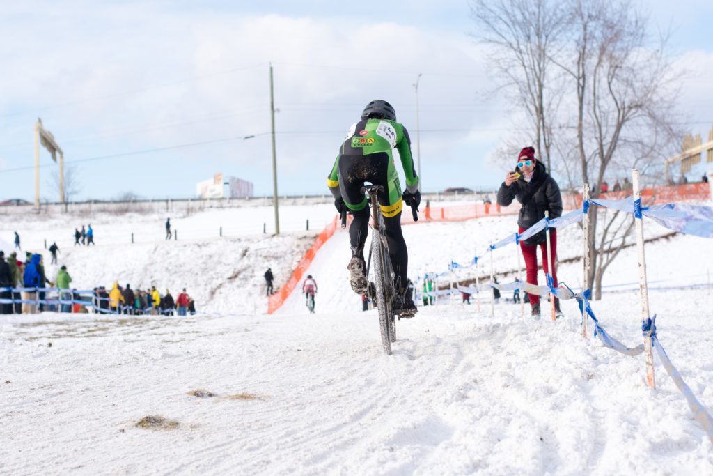 Julie Wright speeds away on a snow covered cyclocross track on a bight winter raceday