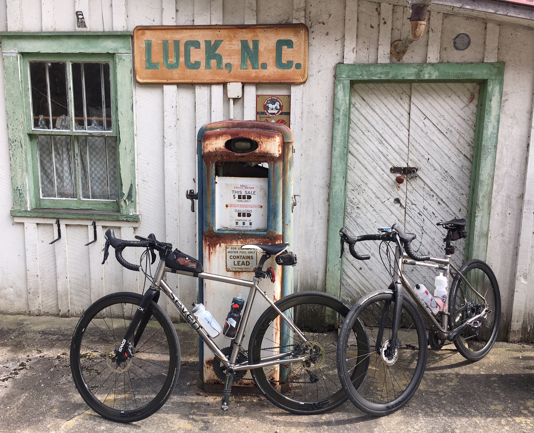 Two Seven touring bikes lean against an abandoned gas station in Luck, North Carolina