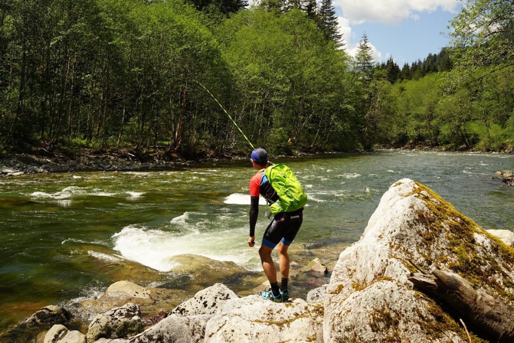 Jeremy stands by a swift forest river