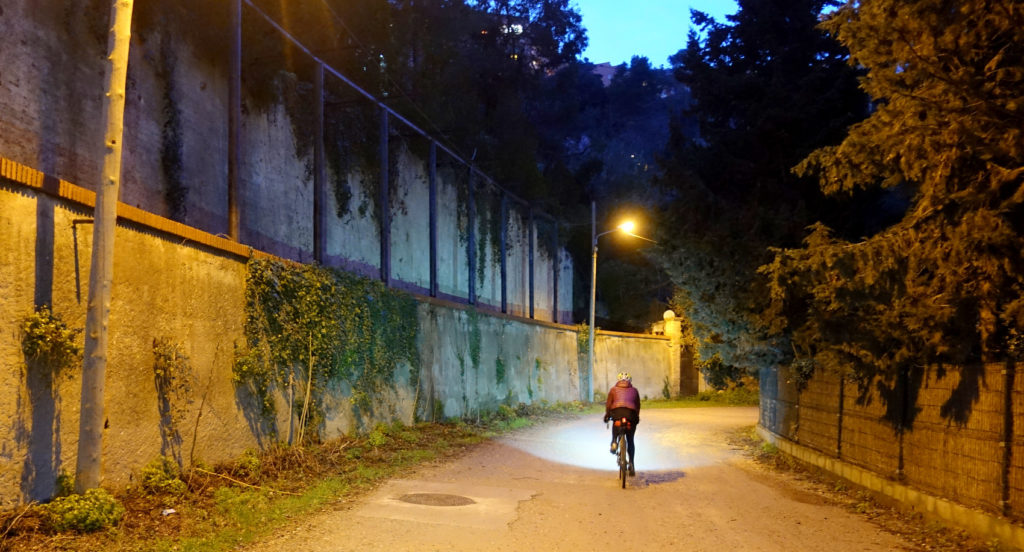 a lone rider pedals through the pre-dawn hours