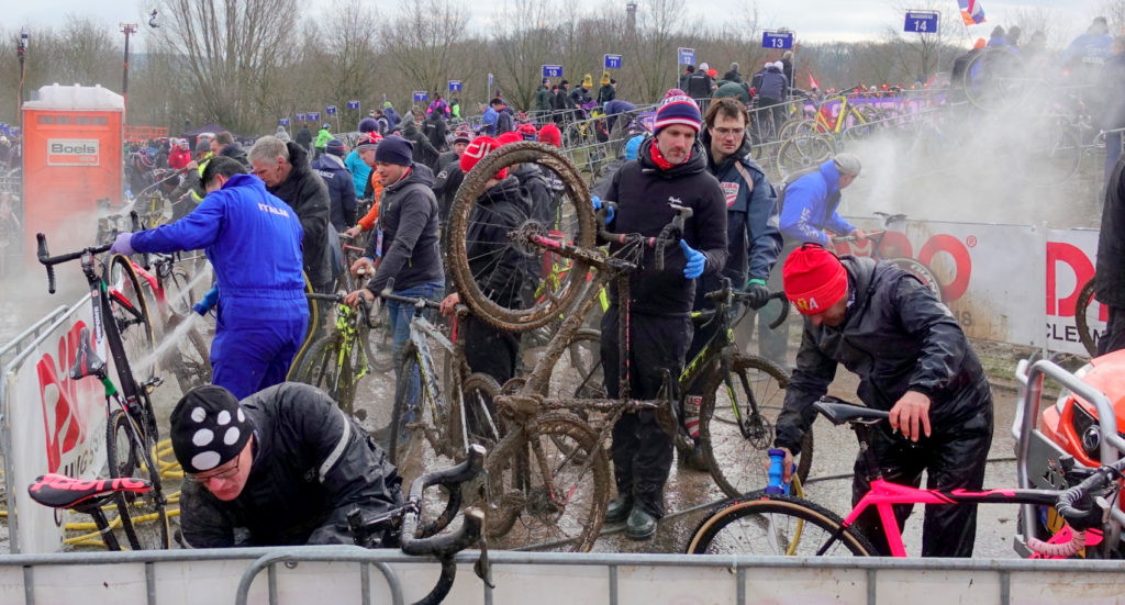A huge group of cyclocross racers wash mud off thier bikes