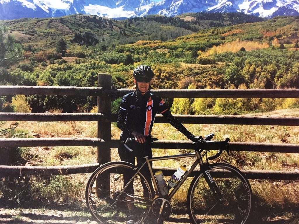 Connie poses with Seven Randonnee bike in front of a stunning view of the mountains