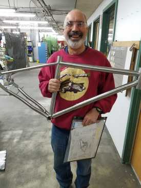 Smiling Dan holds his bicycle frame during a shop tour