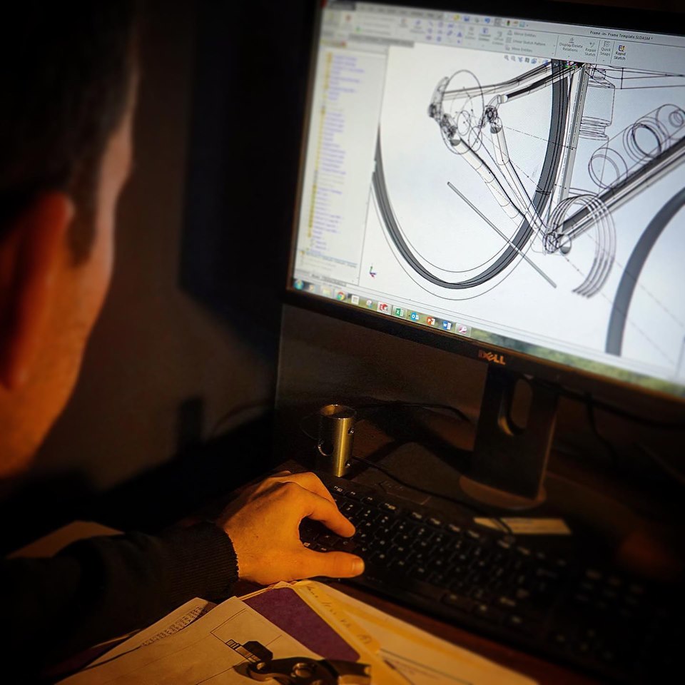 Ryan working in SolidWorks on a bicycle rear triangle in a dark office