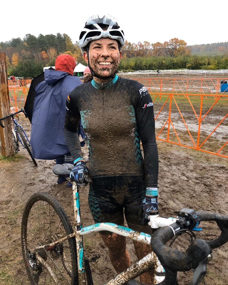 Kelly Cataly grins after being drenched in mud after a cyclocross race
