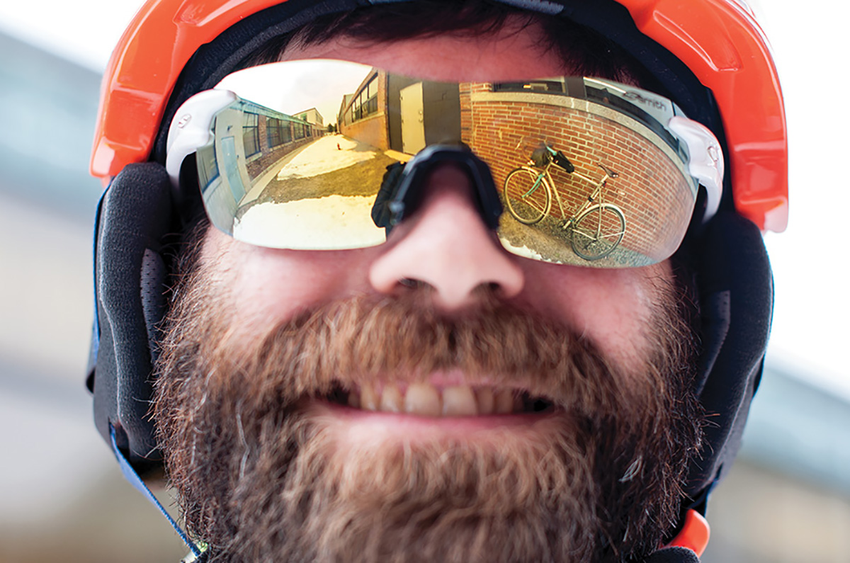 cyclist with his ride reflected in his sunglasses