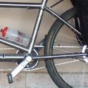 Matt and Suzi's titanium tandem loaded up for touring leans against a brick wall